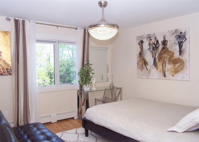 12 Sound View Dr, Rocky Point, NY 11778 - bedroom with baseboard heating, wood finished floors, and a chandelier