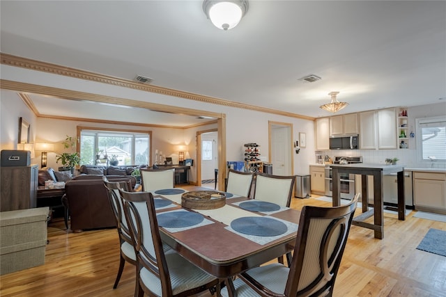 156 E Maujer St, Valley Stream, NY 11580 - dining space featuring healthy amount of natural light, light wood-style flooring, and crown molding