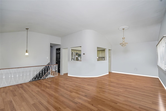 15 Oliver Pl, Staten Island, NY 10314 - unfurnished living room featuring lofted ceiling, wood finished floors, baseboards, and a chandelier