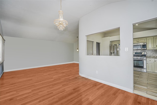 15 Oliver Pl, Staten Island, NY 10314 - unfurnished living room featuring a chandelier, light wood-style floors, baseboards, and lofted ceiling