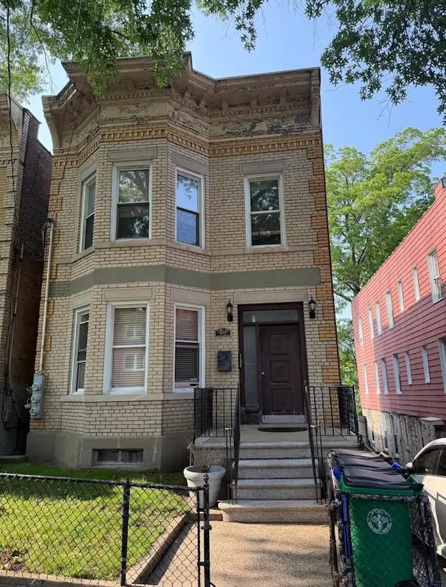 251 E 235th St, Bronx, NY 10470 - view of front facade featuring brick siding and a fenced front yard