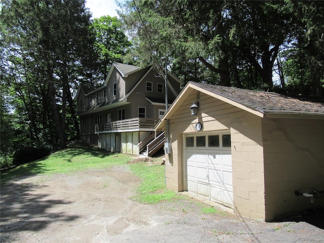 101 Bundy Hill Rd, Holmes, NY 12531 - view of front facade featuring asphalt driveway, concrete block siding, an outdoor structure, and a detached garage