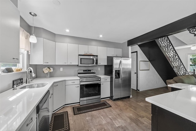 59 Oslo Dr, Yorktown Heights, NY 10598 - kitchen featuring appliances with stainless steel finishes, a sink, wood finished floors, light countertops, and white cabinetry