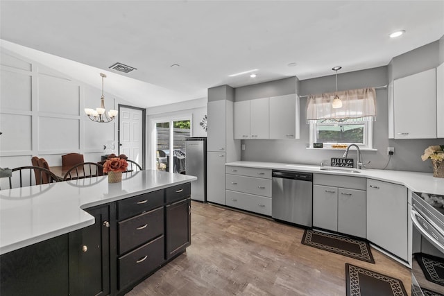 59 Oslo Dr, Yorktown Heights, NY 10598 - kitchen featuring appliances with stainless steel finishes, a sink, a chandelier, wood finished floors, and light countertops