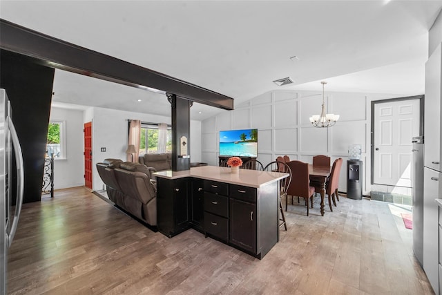 59 Oslo Dr, Yorktown Heights, NY 10598 - kitchen featuring dark cabinets, a chandelier, light wood-style floors, freestanding refrigerator, and light countertops