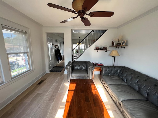 101 Oswego St, North Bellmore, NY 11710 - living area with plenty of natural light, ornamental molding, stairs, light wood-style floors, and ceiling fan