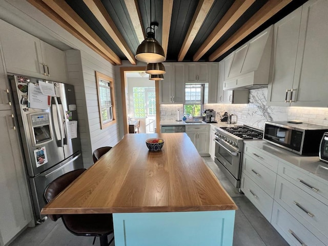 101 Oswego St, North Bellmore, NY 11710 - kitchen with appliances with stainless steel finishes, wall chimney range hood, wood counters, a sink, and decorative backsplash