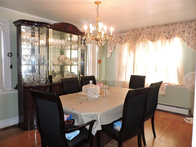 713 Colonial St, Uniondale, NY 11553 - dining area featuring a baseboard radiator, hardwood / wood-style floors, a chandelier, and baseboards