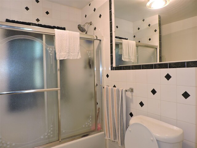 713 Colonial St, Uniondale, NY 11553 - bathroom with tile walls, toilet, and shower / bath combination with glass door