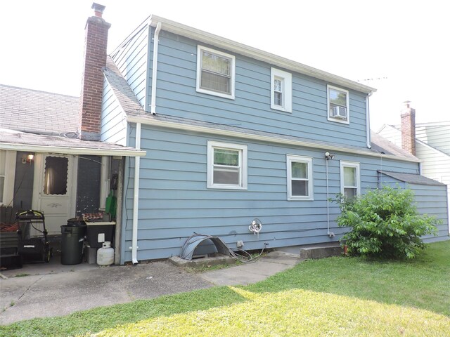 713 Colonial St, Uniondale, NY 11553 - back of house with a yard, a chimney, and a patio area