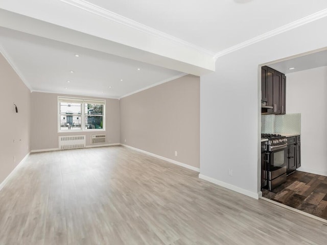 642 Locust St Unit 2D, Mount Vernon, NY 10552 - unfurnished living room with radiator, light wood finished floors, a wall mounted air conditioner, baseboards, and ornamental molding