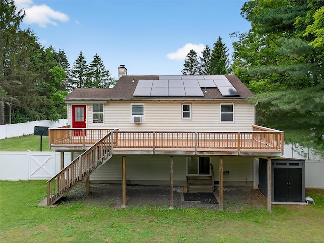 98 Greenhaven Rd, Poughquag, NY 12570 - rear view of house featuring a wooden deck, a chimney, roof mounted solar panels, stairs, and a fenced backyard