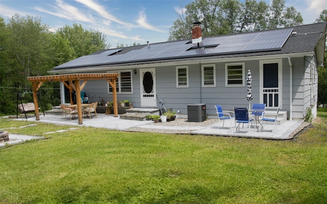 52 Old Chester Rd, Goshen, NY 10924 - rear view of house with a yard, a patio area, roof mounted solar panels, a chimney, and cooling unit