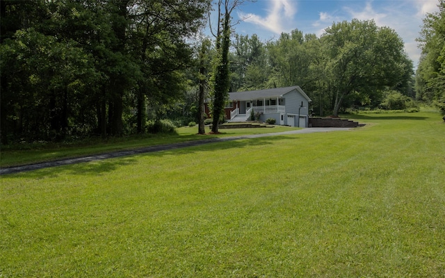 52 Old Chester Rd, Goshen, NY 10924 - view of grassy yard featuring a garage and asphalt driveway
