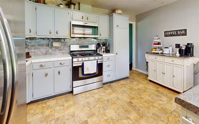 52 Old Chester Rd, Goshen, NY 10924 - kitchen featuring stainless steel appliances, stone finish floors, backsplash, baseboards, and tile counters