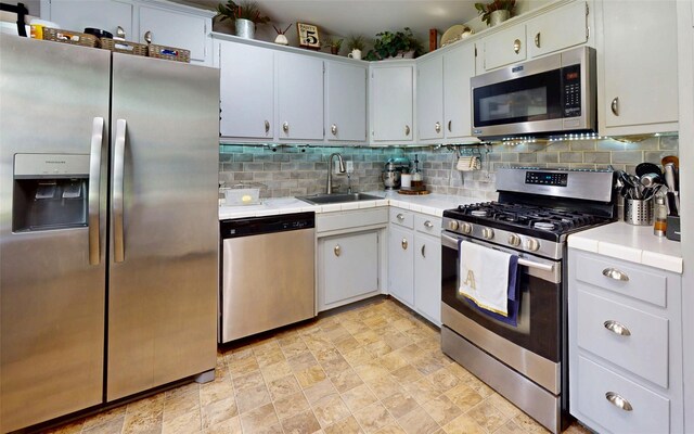 52 Old Chester Rd, Goshen, NY 10924 - kitchen featuring stainless steel appliances, a sink, decorative backsplash, and tile countertops