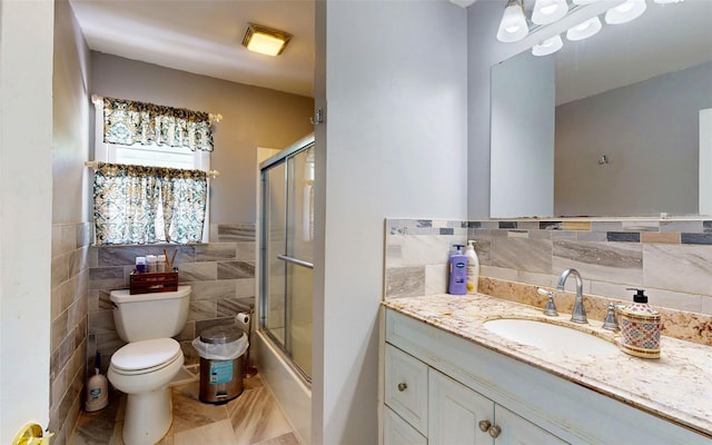 52 Old Chester Rd, Goshen, NY 10924 - bathroom featuring tile walls, toilet, vanity, tile patterned floors, and shower / bath combination with glass door