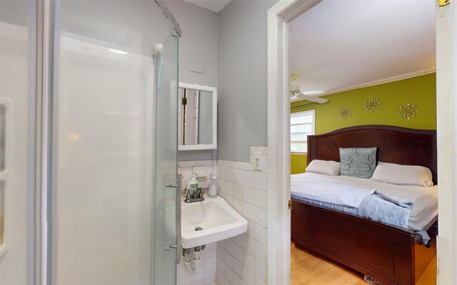 52 Old Chester Rd, Goshen, NY 10924 - bathroom featuring a sink, tile walls, a stall shower, a ceiling fan, and wood finished floors