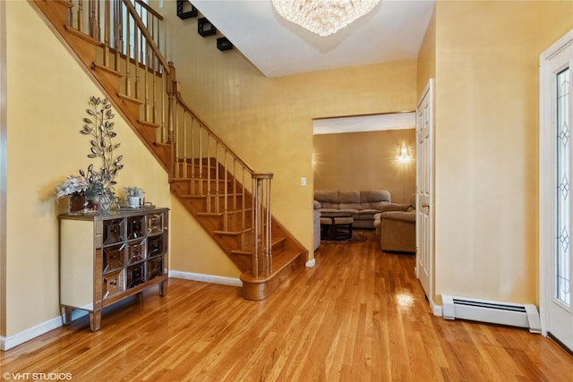 10 Wyllys Ct, Rock Tavern, NY 12575 - foyer with baseboard heating, wood finished floors, stairway, and a chandelier