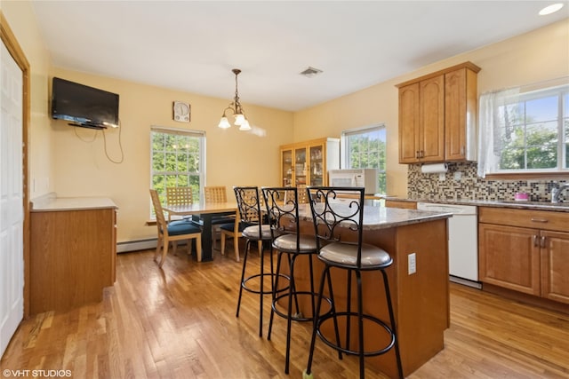 10 Wyllys Ct, Rock Tavern, NY 12575 - kitchen with white dishwasher, light wood-type flooring, a breakfast bar area, and plenty of natural light