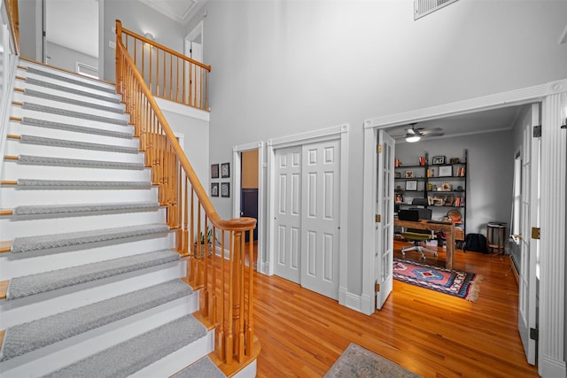 32 Woodcrest Ln, Goshen, NY 10924 - stairs with wood finished floors, ornamental molding, a towering ceiling, ceiling fan, and baseboards