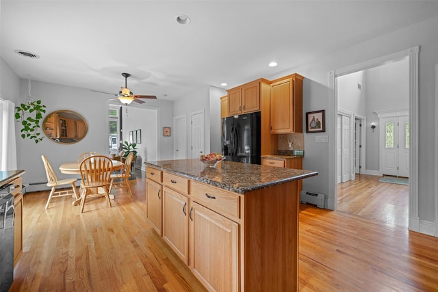 32 Woodcrest Ln, Goshen, NY 10924 - kitchen with black fridge with ice dispenser, a baseboard radiator, light wood finished floors, a ceiling fan, and a kitchen island