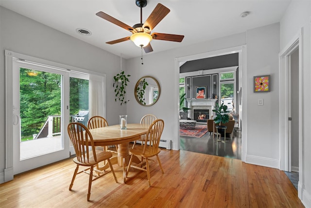 32 Woodcrest Ln, Goshen, NY 10924 - dining space featuring plenty of natural light, a glass covered fireplace, and light wood finished floors