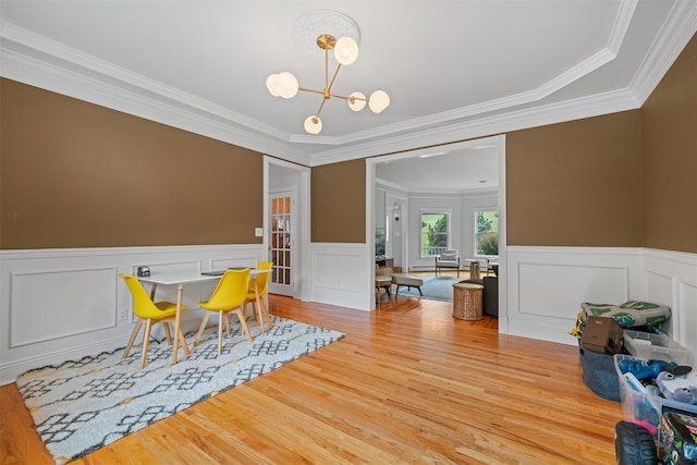32 Woodcrest Ln, Goshen, NY 10924 - dining space featuring crown molding, wood finished floors, a chandelier, wainscoting, and a decorative wall