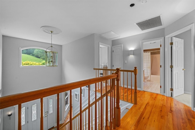 32 Woodcrest Ln, Goshen, NY 10924 - corridor featuring an upstairs landing, light wood-style flooring, baseboards, and a chandelier