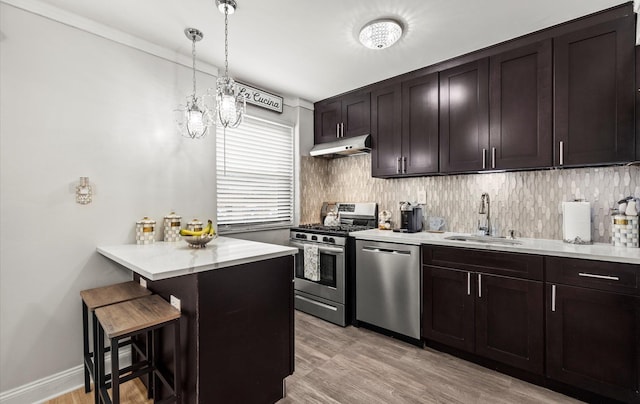 155-03 79th St Unit 188, Howard Beach, NY 11414 - kitchen with appliances with stainless steel finishes, a sink, under cabinet range hood, a kitchen bar, and light countertops