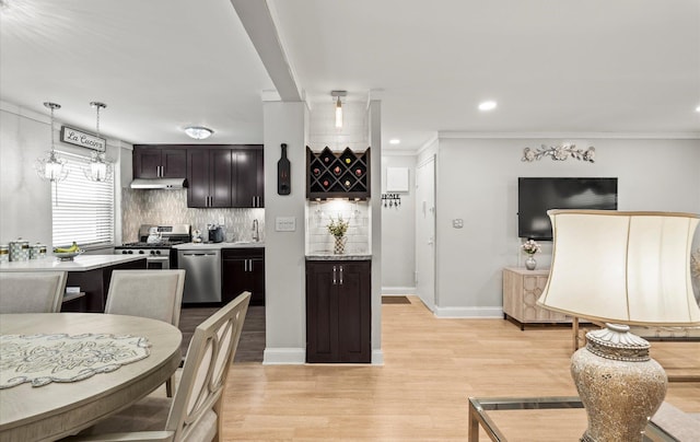 155-03 79th St Unit 188, Howard Beach, NY 11414 - kitchen featuring stainless steel appliances, under cabinet range hood, tasteful backsplash, light countertops, and light wood-type flooring