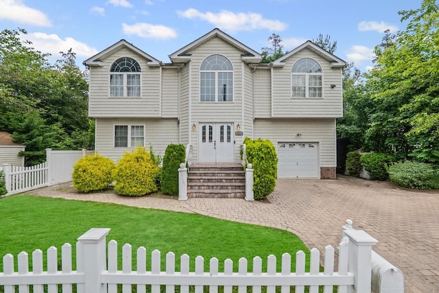 361 Locust Pl, Freeport, NY 11520 - view of front of property featuring a fenced front yard, decorative driveway, and a garage