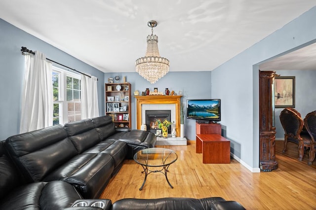 361 Locust Pl, Freeport, NY 11520 - living area featuring a chandelier, wood finished floors, and a fireplace with raised hearth
