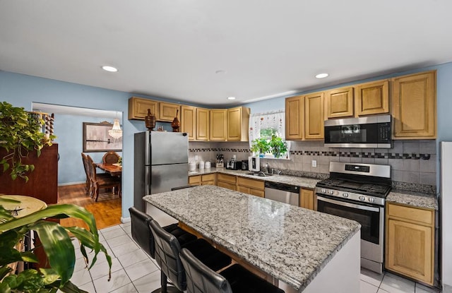 361 Locust Pl, Freeport, NY 11520 - kitchen featuring stainless steel appliances, a kitchen island, backsplash, light stone counters, and recessed lighting