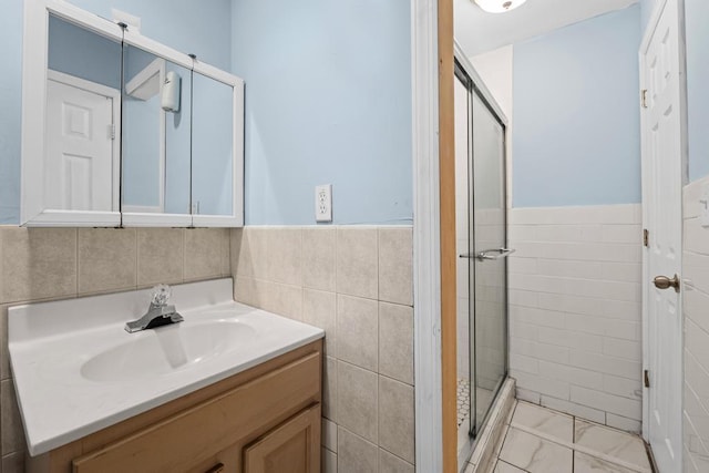361 Locust Pl, Freeport, NY 11520 - bathroom featuring a shower stall, vanity, marble look tiles, tile walls, and a wainscoted wall