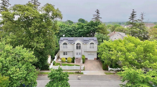 361 Locust Pl, Freeport, NY 11520 - view of front of house with an attached garage, roof mounted solar panels, and concrete driveway