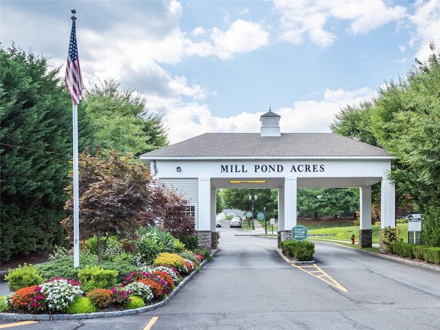 158 Pond View Dr, Port Washington, NY 11050 - view of asphalt road with curbs, traffic signs, and a gated entry