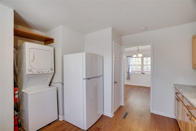 3 Chappell Pkwy, Middletown, NY 10940 - laundry room with estacked washer and dryer, light wood-type flooring, baseboards, and a chandelier