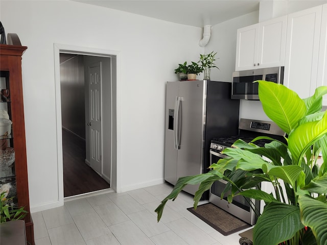 3039 Fulton St, Brooklyn, NY 11208 - kitchen featuring appliances with stainless steel finishes, white cabinetry, and baseboards