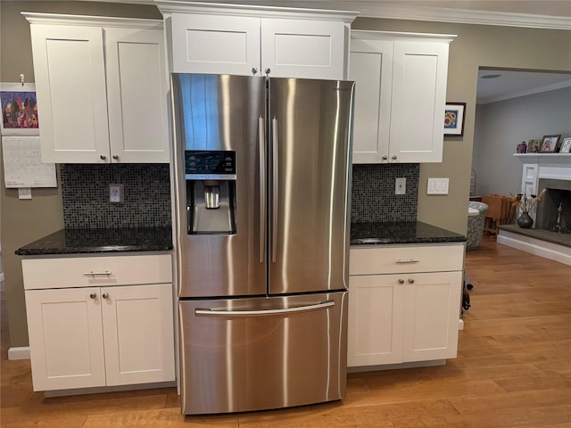7 Yorkshire Ave, Stony Brook, NY 11790 - kitchen featuring stainless steel refrigerator with ice dispenser, ornamental molding, backsplash, dark stone counters, and light wood-style floors