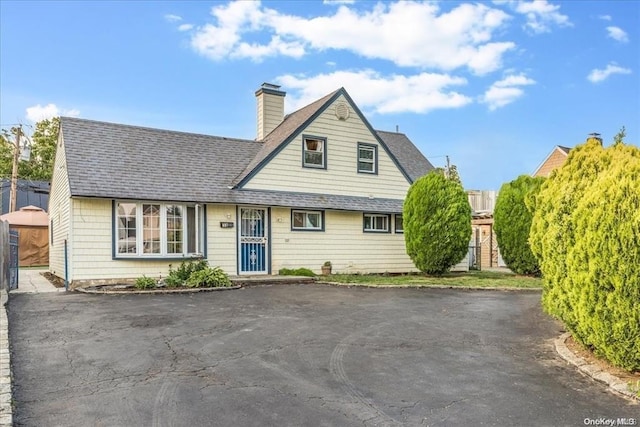 15 Marksman Ln, Levittown, NY 11756 - view of front of house with a shingled roof and a chimney