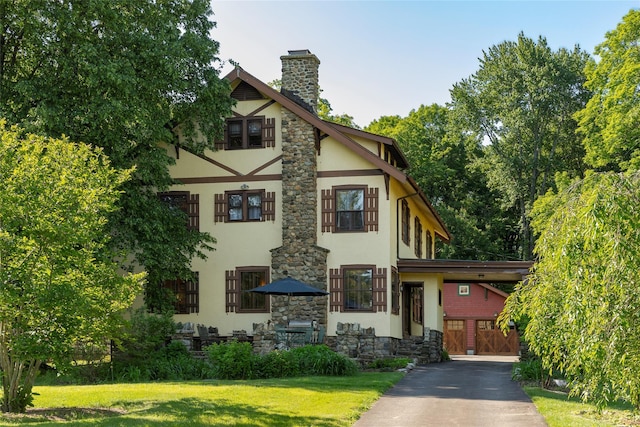 8 Elmer Galloway Rd, Katonah, NY 10536 - tudor-style house featuring stucco siding, stone siding, a chimney, and a front lawn