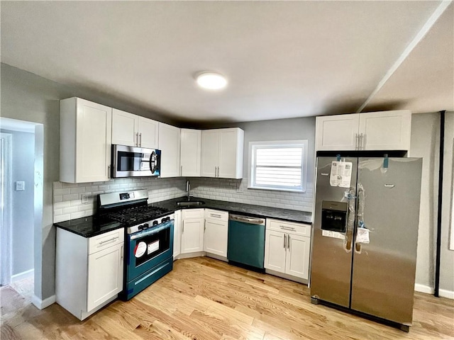 1231 E 88th St, Brooklyn, NY 11236 - kitchen with stainless steel appliances, a sink, white cabinetry, decorative backsplash, and dark countertops