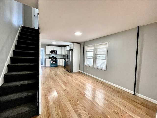 1231 E 88th St, Brooklyn, NY 11236 - unfurnished living room with stairs, light wood-style floors, baseboards, and recessed lighting