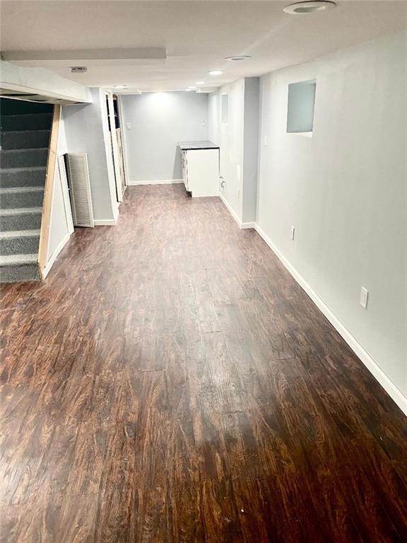 1231 E 88th St, Brooklyn, NY 11236 - finished below grade area with dark wood-style flooring, stairs, and baseboards