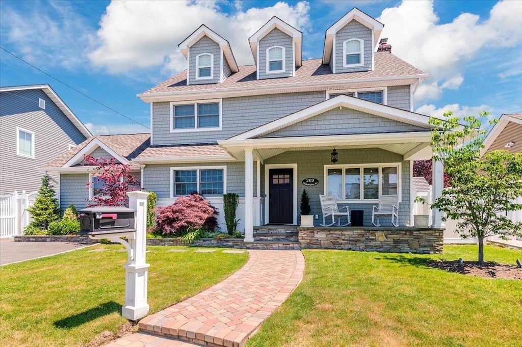 309 Philadelphia Ave, Massapequa Park, NY 11762 - view of front of property with a porch, a front lawn, and roof with shingles