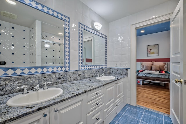 18 Harriman Dr, Sands Point, NY 11050 - full bathroom with tile patterned floors, tile walls, a stall shower, connected bathroom, and double vanity