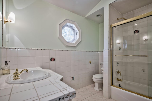 18 Harriman Dr, Sands Point, NY 11050 - full bathroom with tile walls, combined bath / shower with glass door, vaulted ceiling, vanity, and tile patterned floors