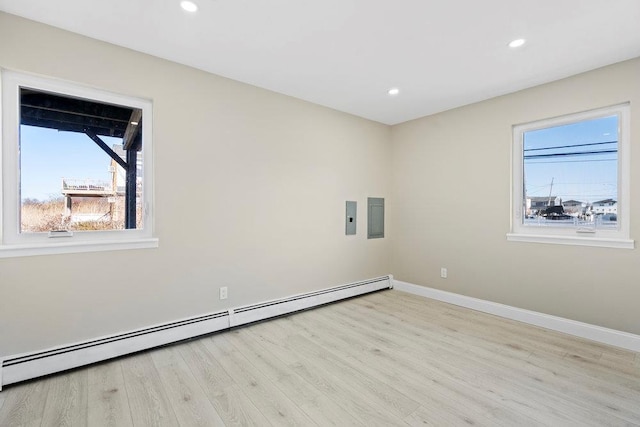 2850 Shore Rd, Seaford, NY 11783 - empty room with baseboard heating, healthy amount of natural light, baseboards, wood finished floors, and recessed lighting