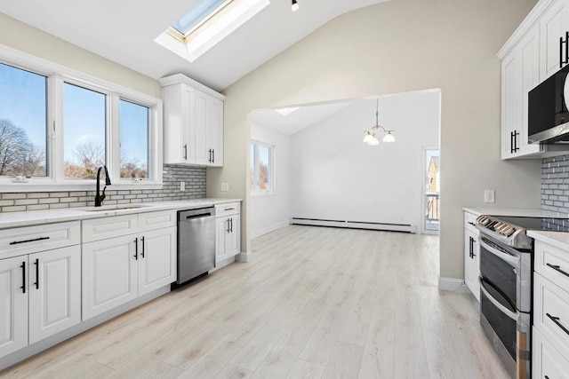 2850 Shore Rd, Seaford, NY 11783 - kitchen featuring stainless steel appliances, a sink, a baseboard heating unit, lofted ceiling, and tasteful backsplash